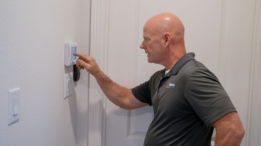 technician working on thermostat in hallway