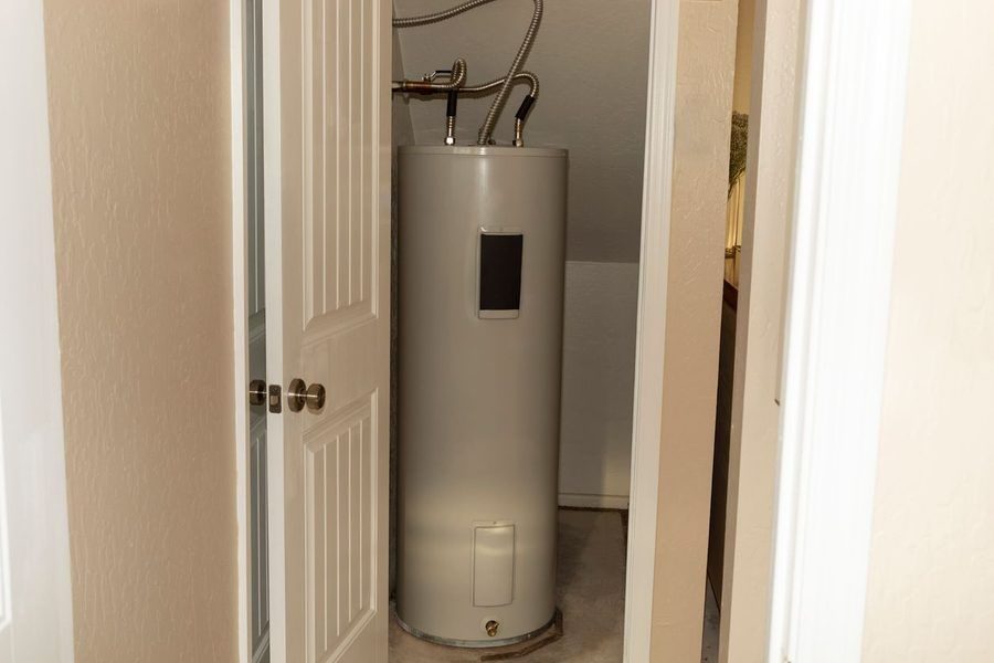 Standard tank water heater in utility closet in a house